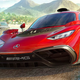 Two cars going very fast on a road near a bright and sunny beach.
